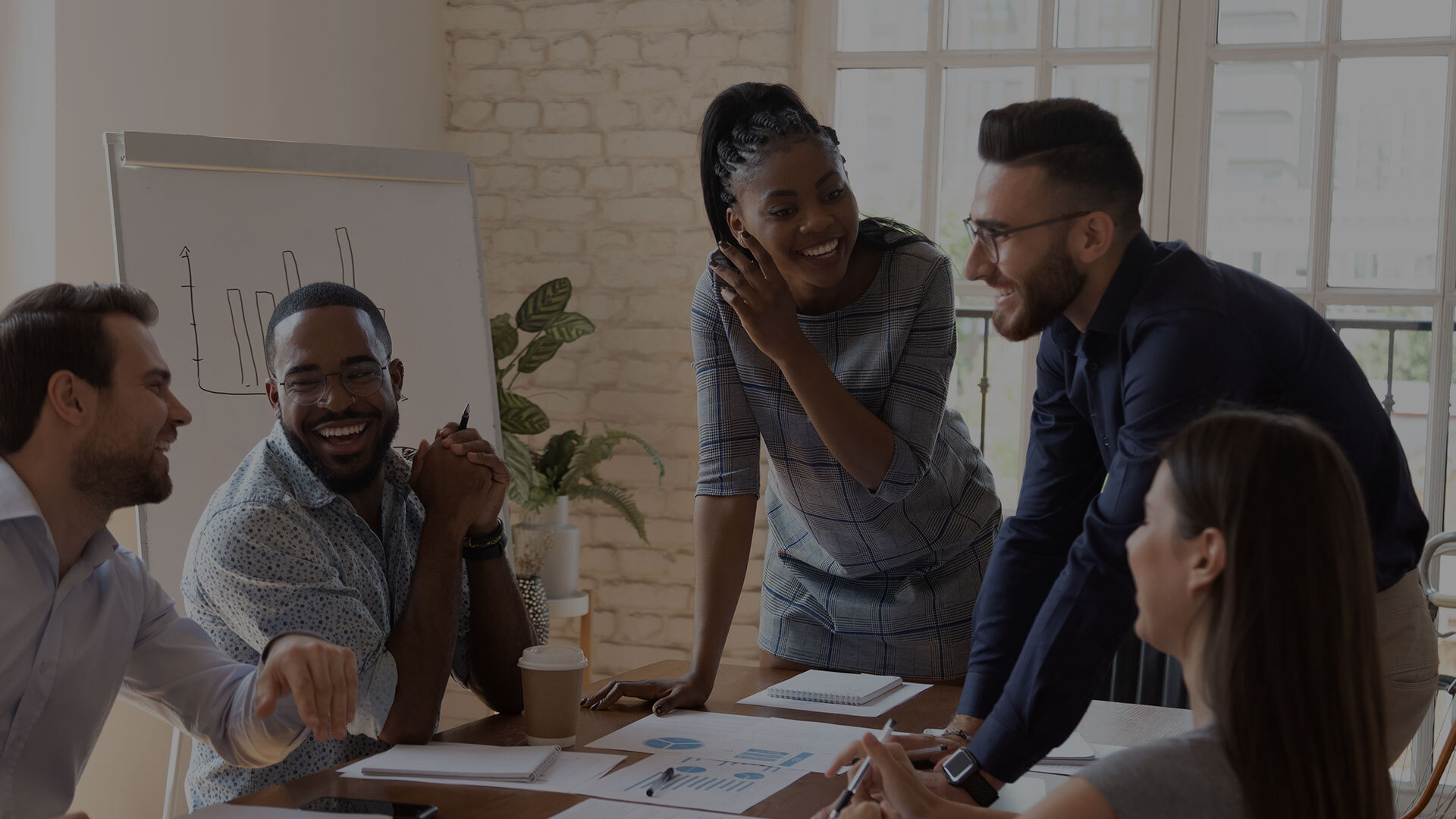 improve employee retention - employees standing in a circle meeting and laughing