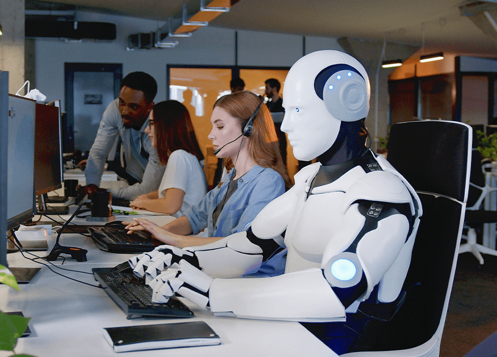 In a call center office, a robot works, typing on the computer among human employees