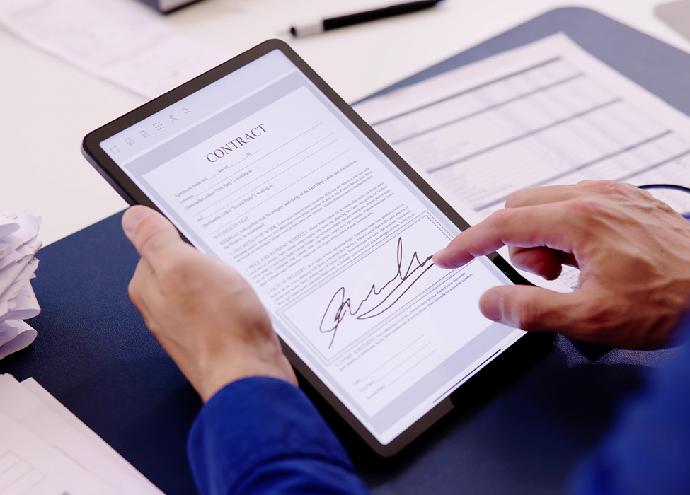 Person signs a digital contract on their tablet