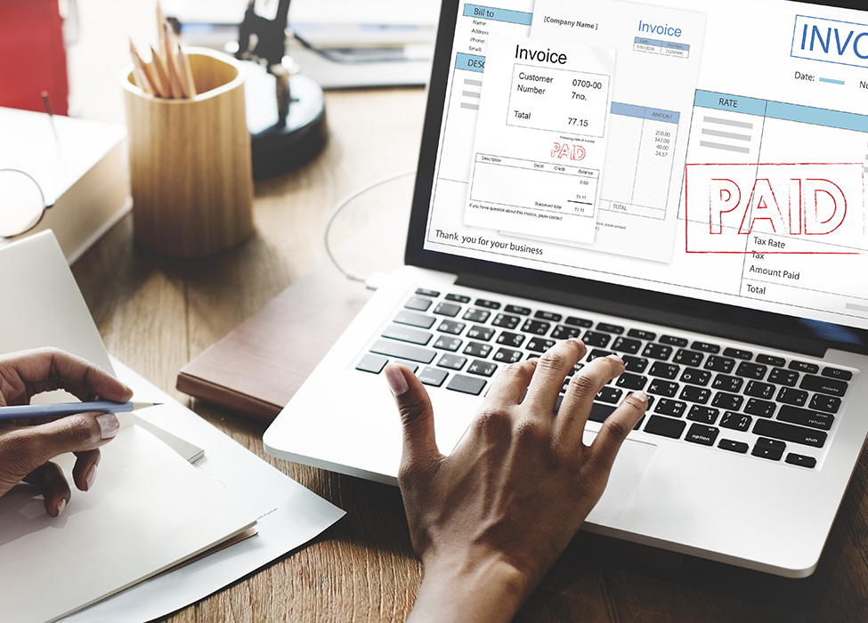 Image of laptop with an invoice marked paid
