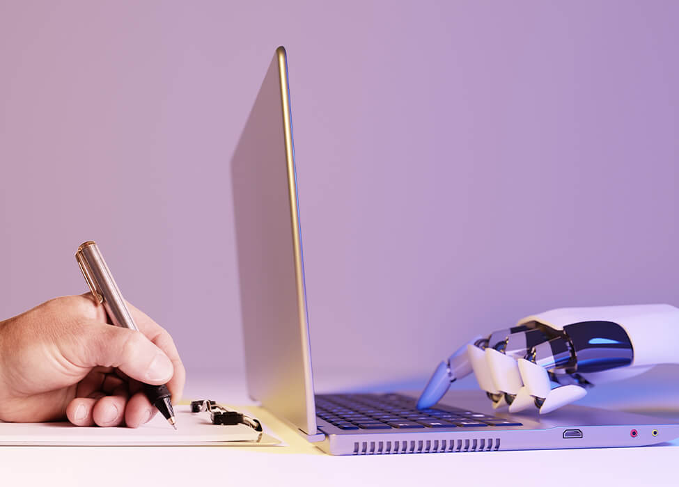 A human hand and a robotic hand collaborating on a task with a laptop, illustrating the synergy between humans and machines through hyperautomation.