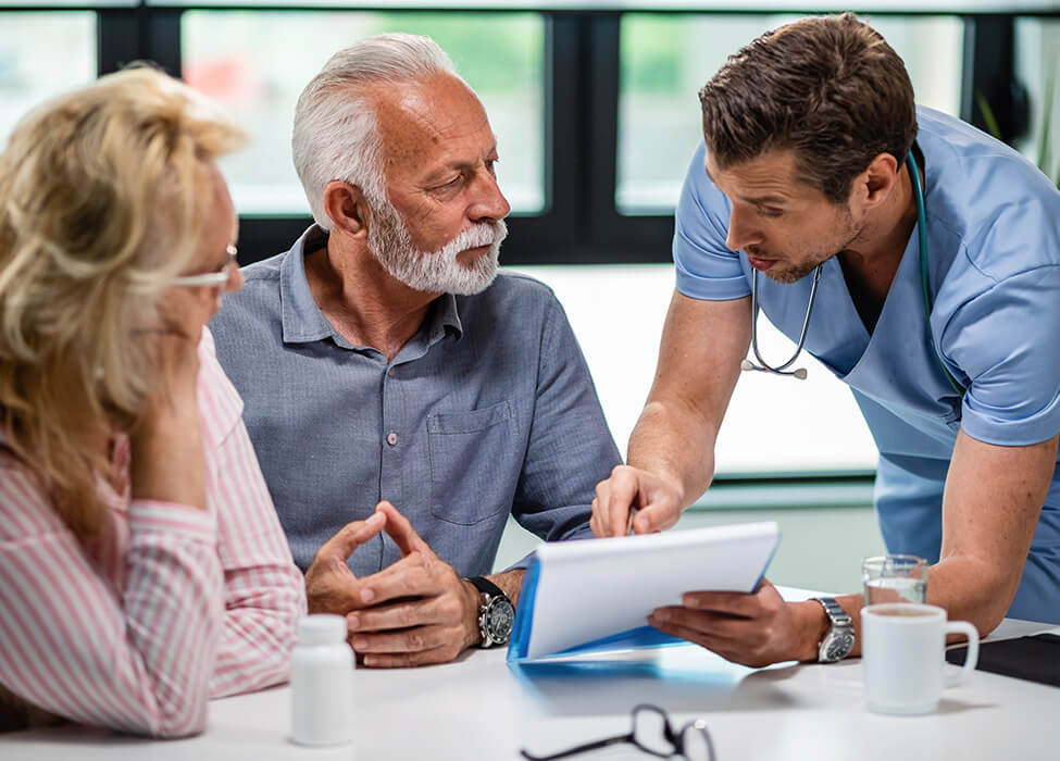 Provider with clipboard discussing options with an elderly couple