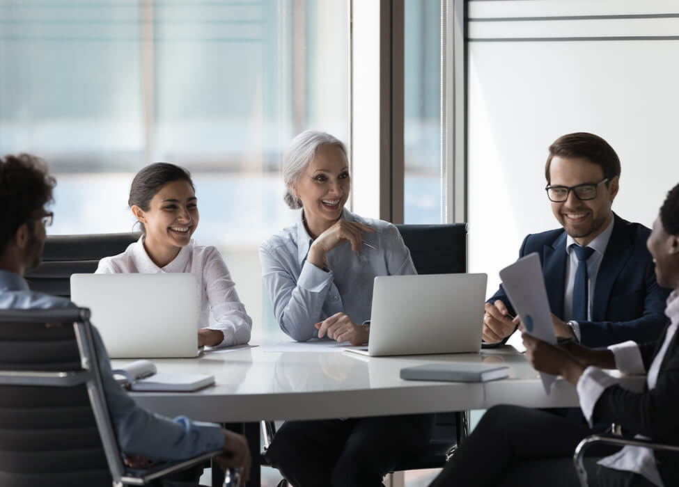 Several smiling and laughing during a meeting in the office