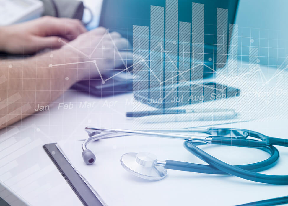 Healthcare professional using a laptop with a stethoscope and financial charts overlayed, representing revenue integrity in healthcare.