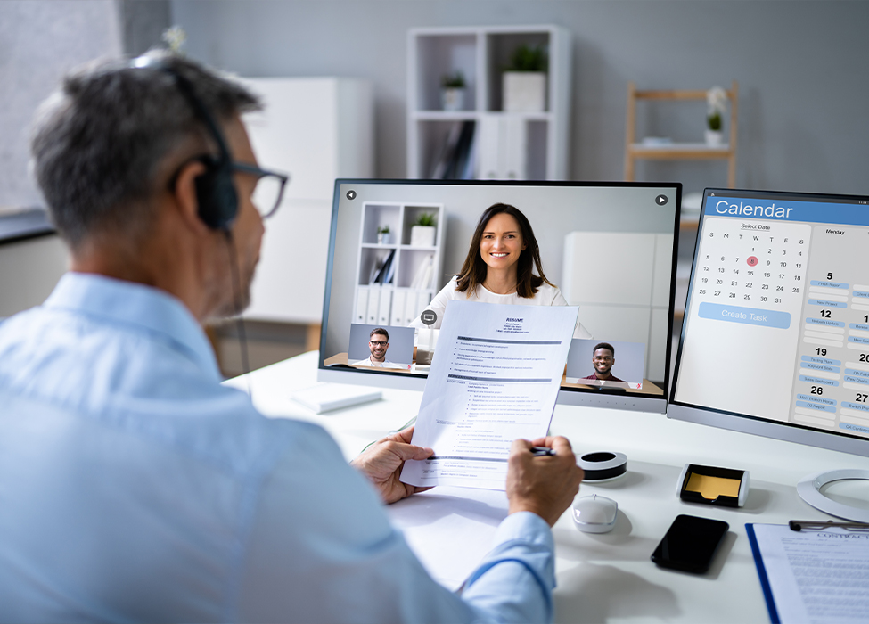 Hybrid working | Person looking at a paper while in an online meeting 