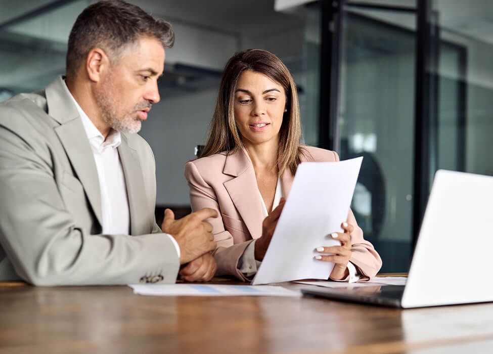 Two professionals looking over a document together