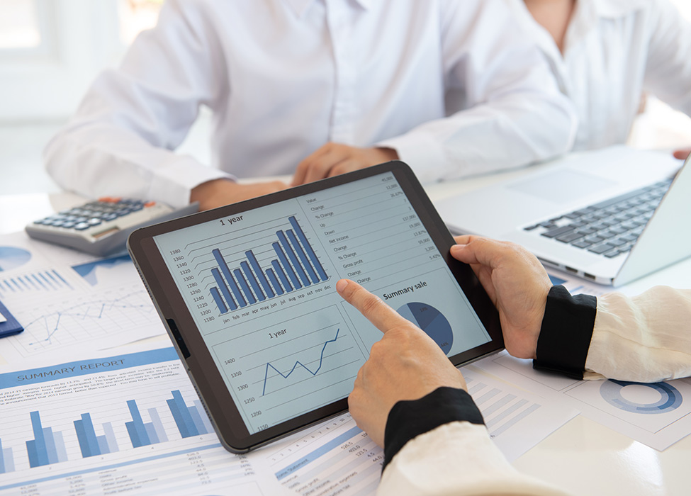 medical coding solutions: People in doctor's coats looking over papers and a tablet with graphs on it