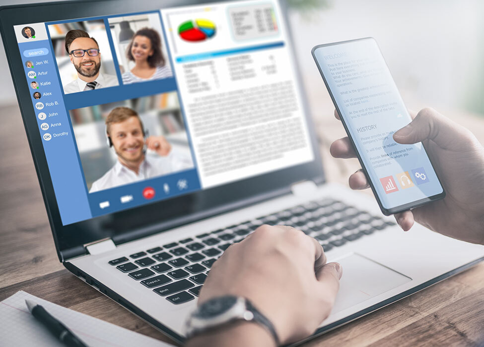 future of remote working | close up of person in a virtual meeting on their laptop while checking information on their phone