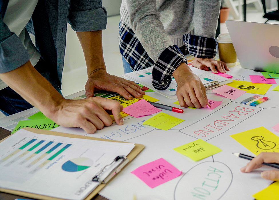 Non-Digital Marketing | People look at and touch papers scattered on the table