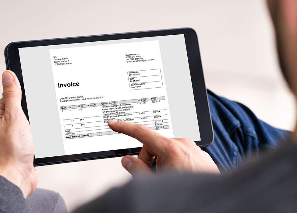 billing and payment solutions | person is looking at their tablet that shows an invoice on the screen